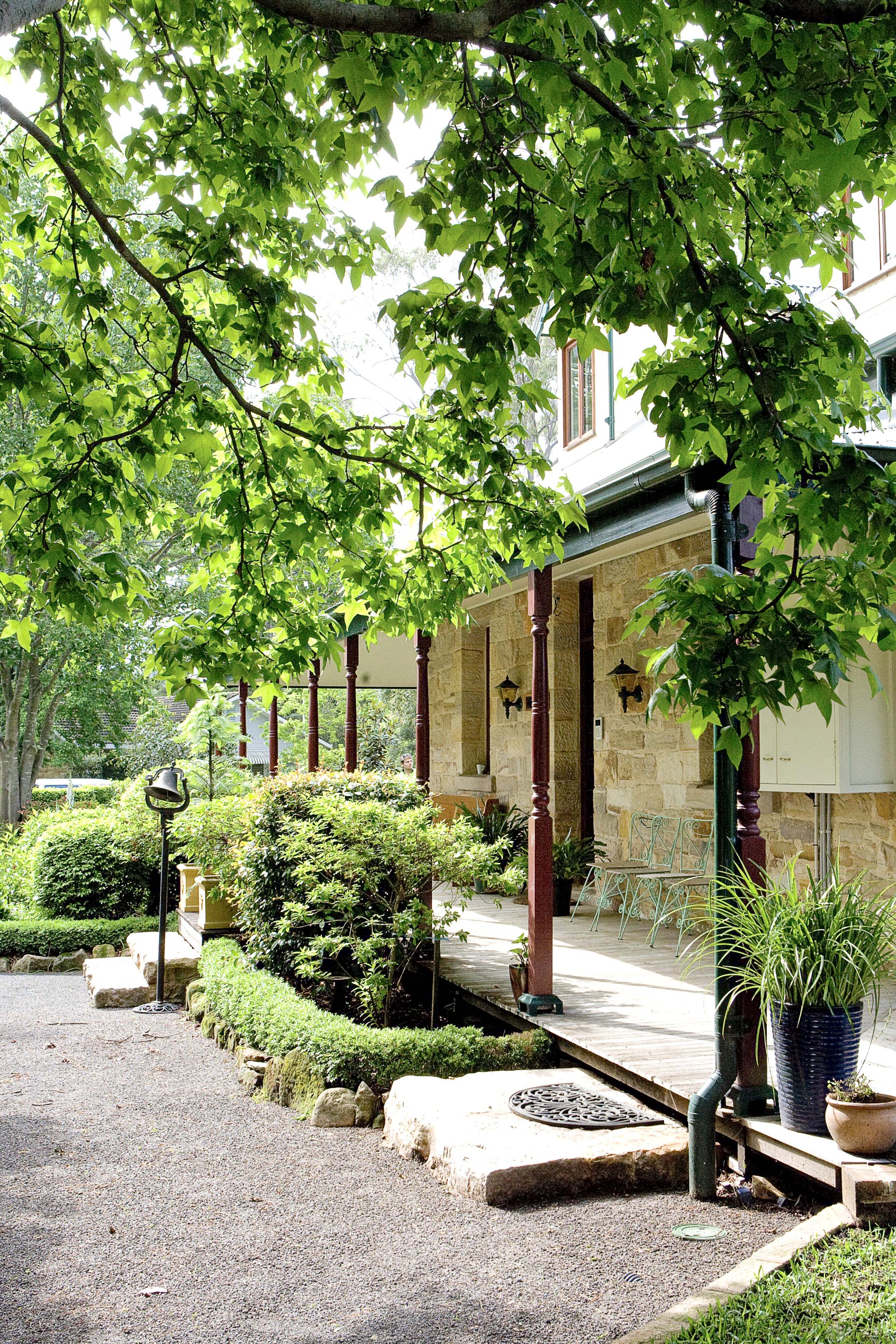  Twin sandstone planters, 
home to a pair of rare Wollemi pines, flank the front steps of a stone homestead in the NSW Blue Mountains.