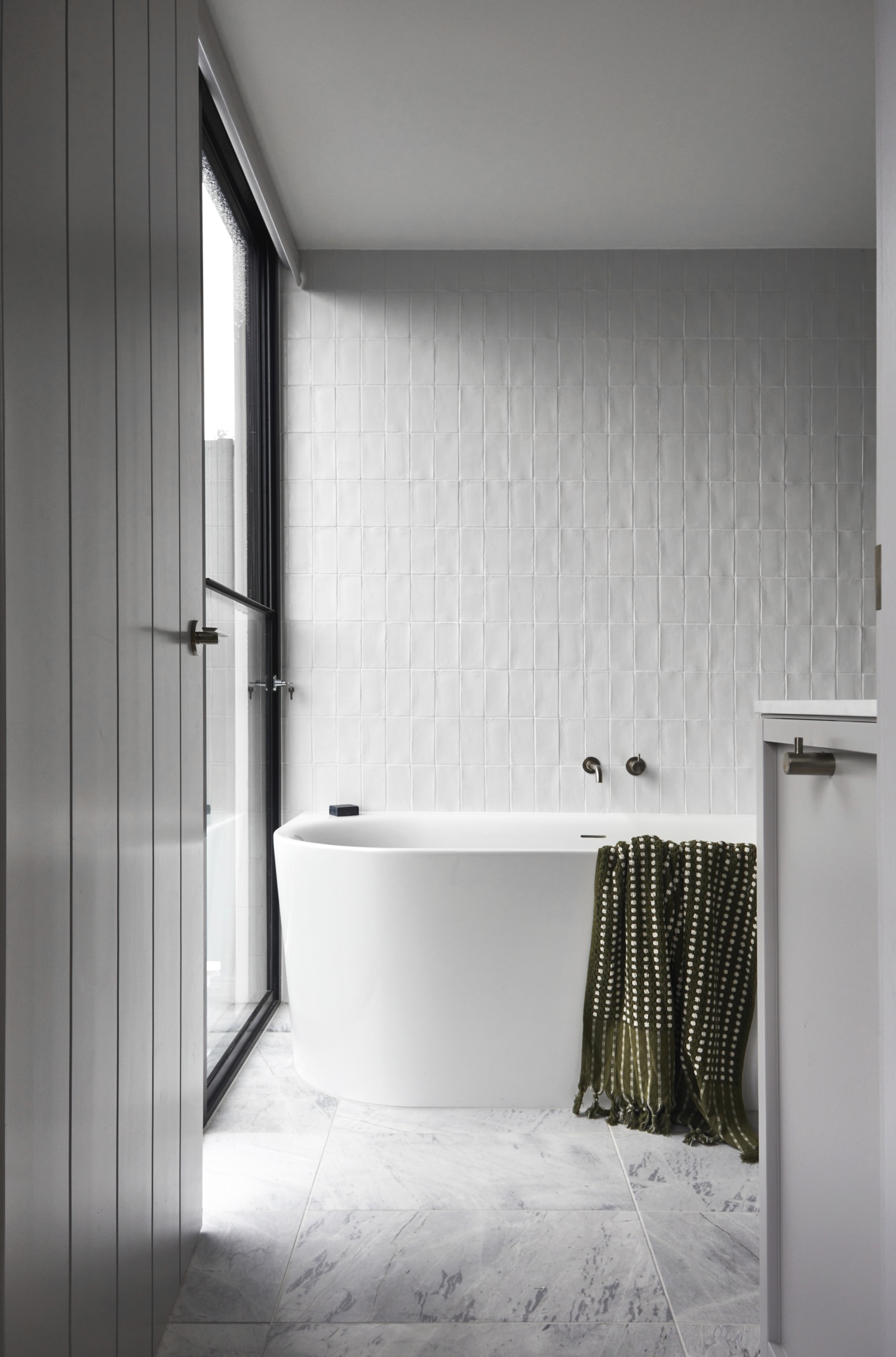 ensuite with white wall tiles and grey marble floor