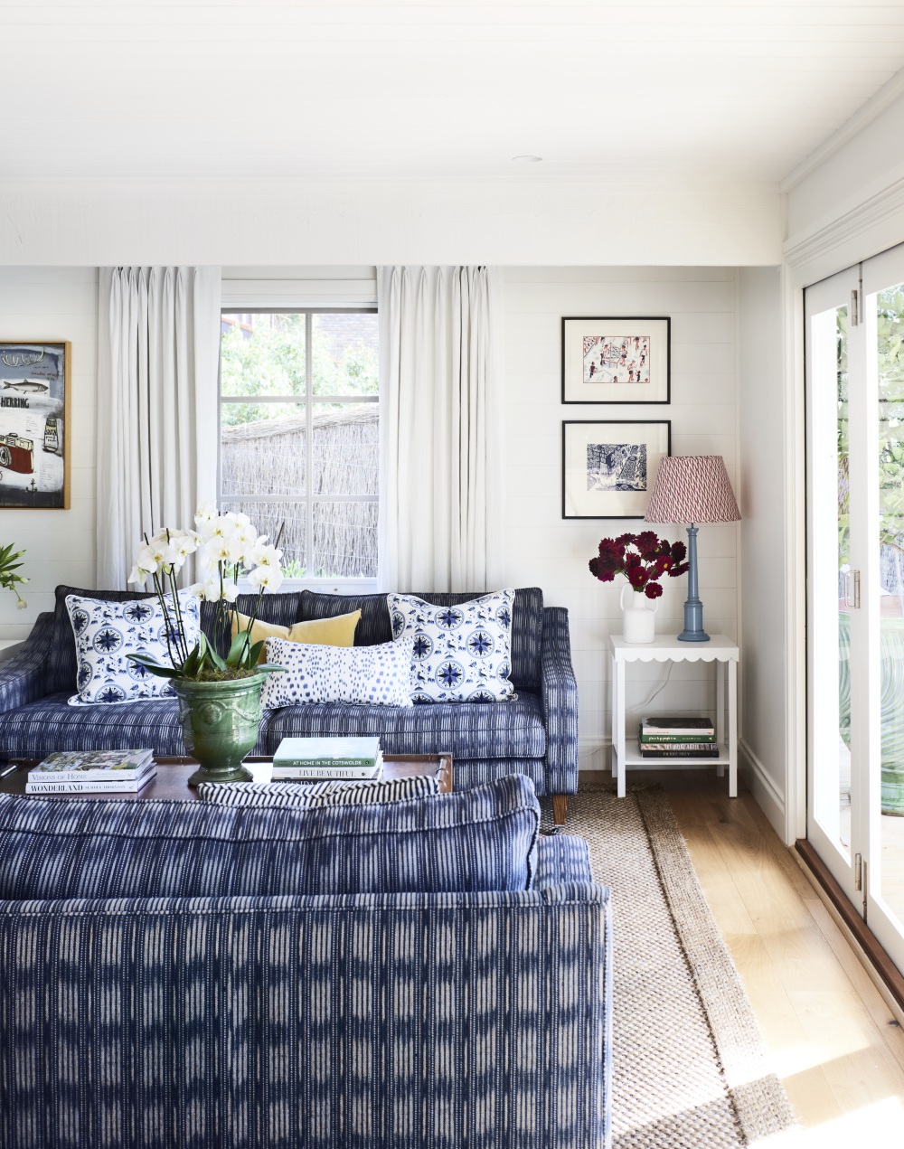 Light living room with sisal rug and blue and white sofa