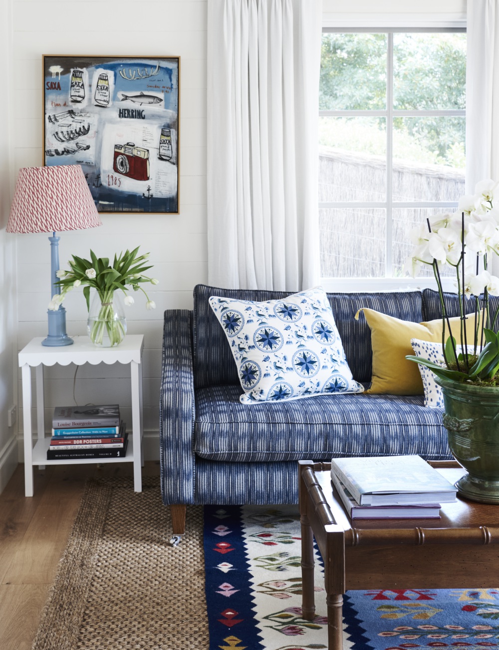 Light living room with blue and white sofa and sisal rug