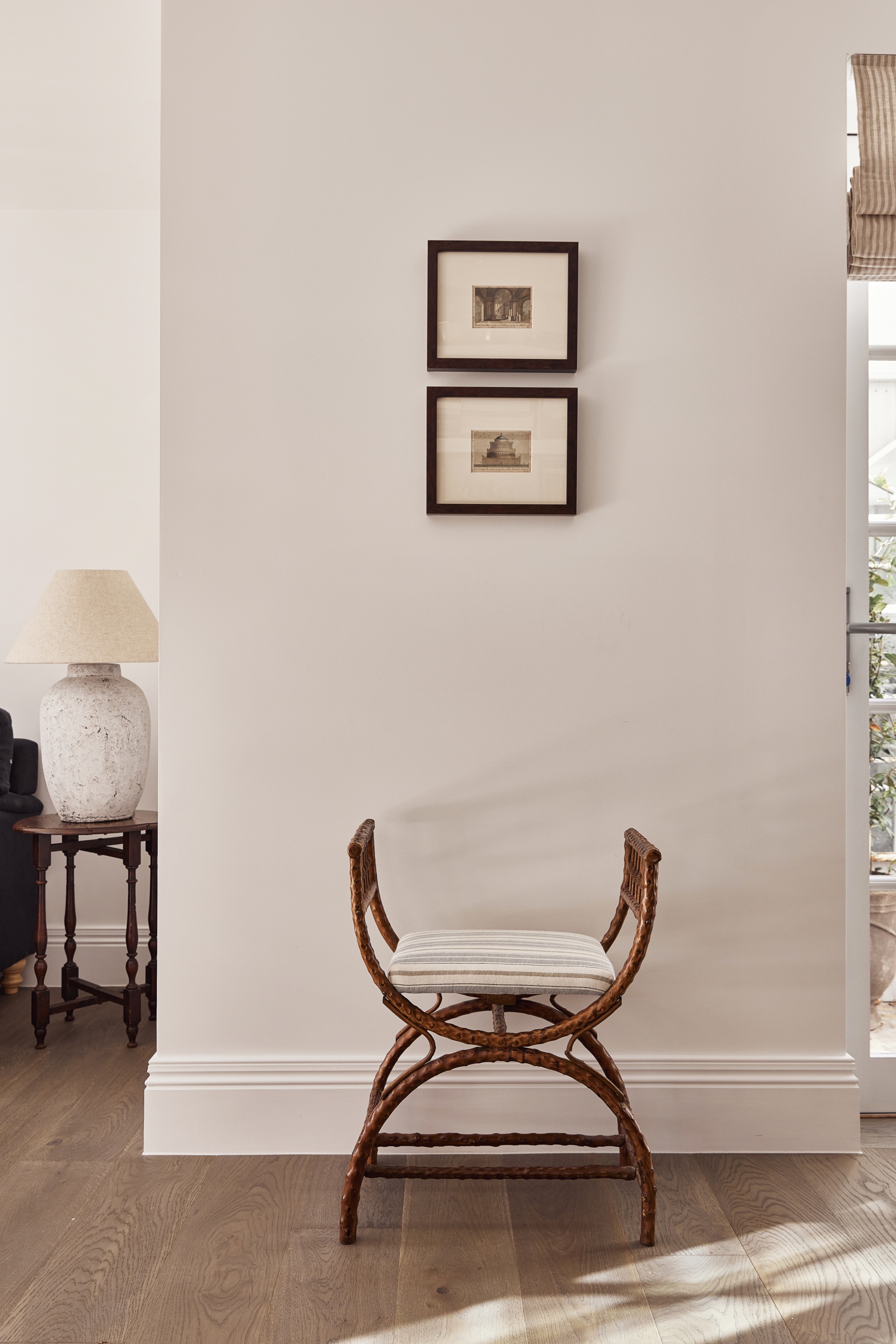 Picture frames hang above a French style chair.