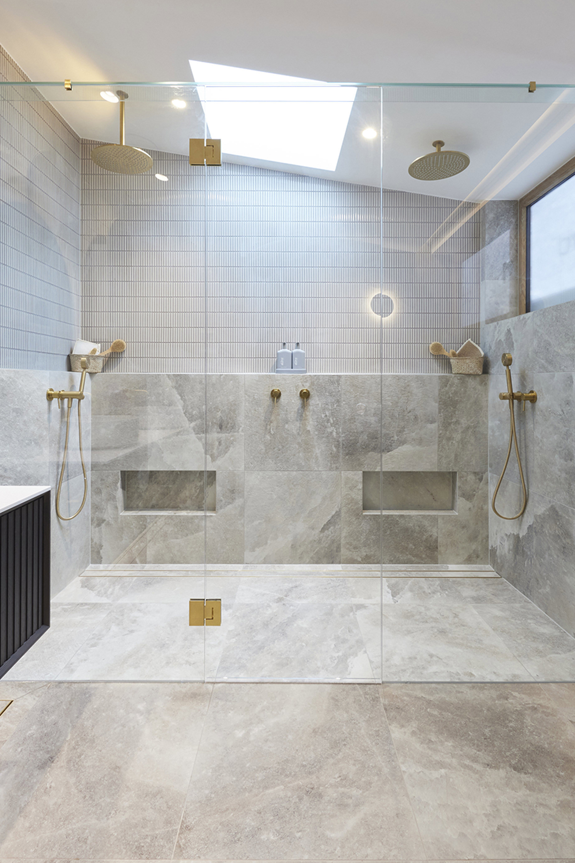 Contemporary bathroom with double shower, shelving ledge and foot rest niches. 