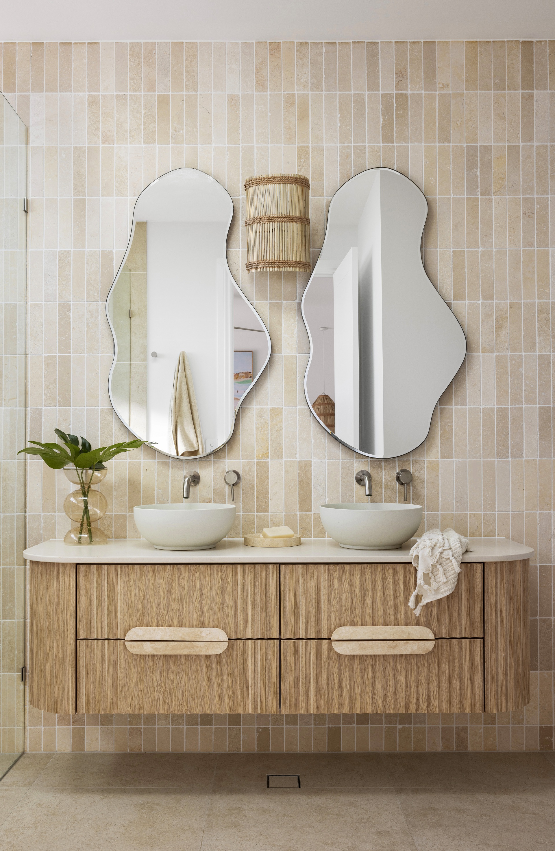 An ensuite with a fluted timber vanity and stone subway tiles.