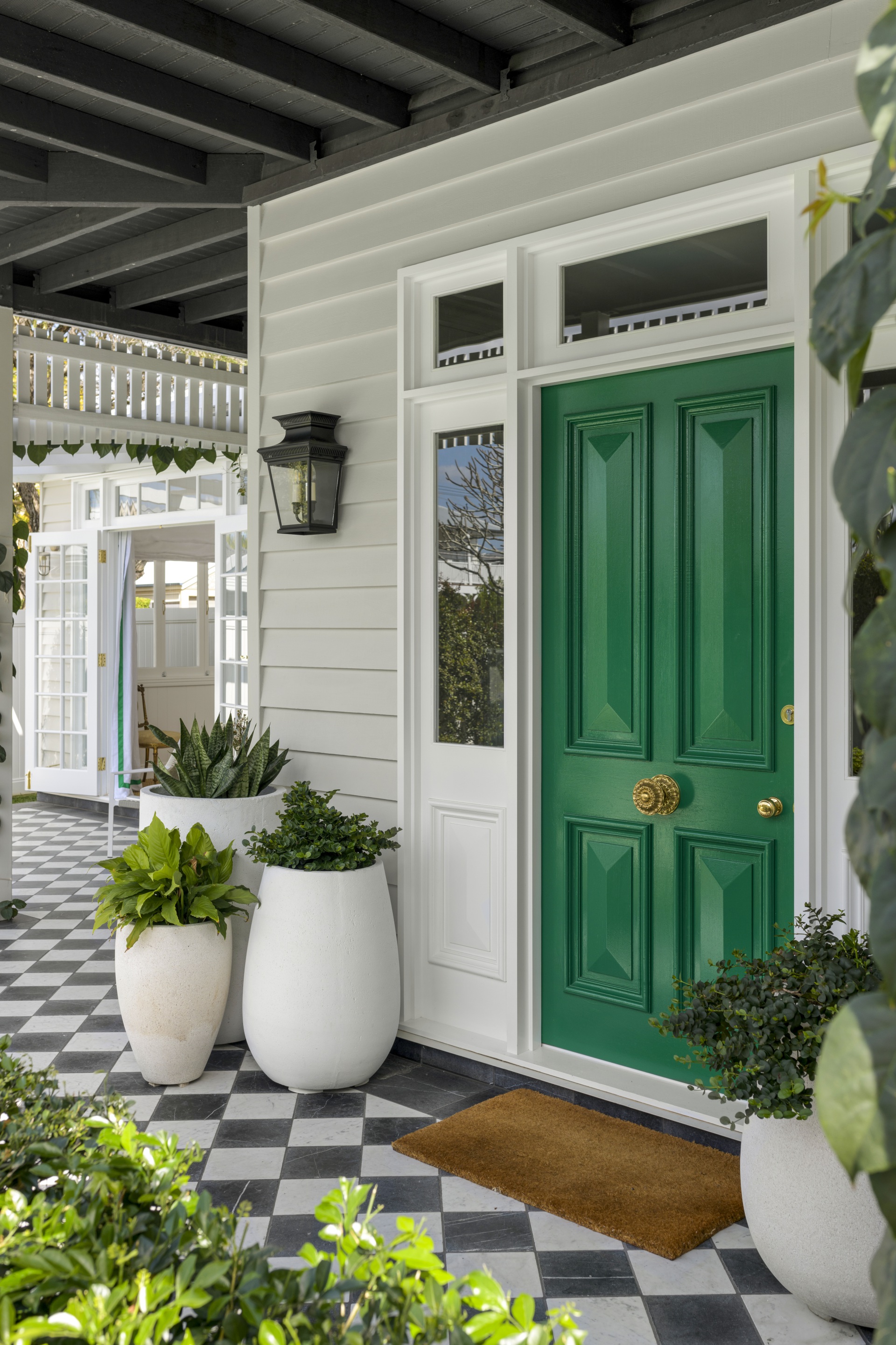 A vibrant green front door with a classic checked floor.