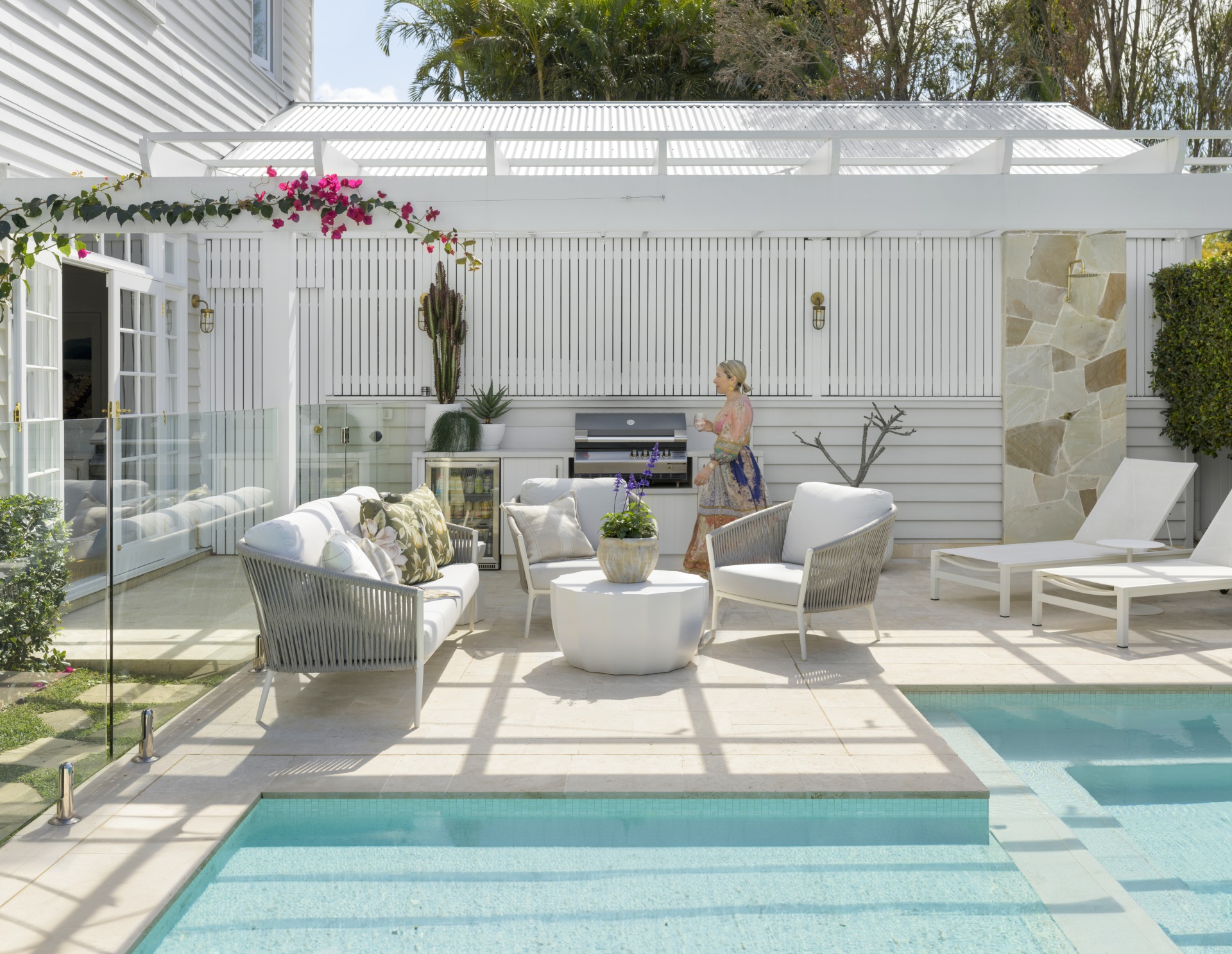 The pool area with white sun loungers and interior designer Tori.