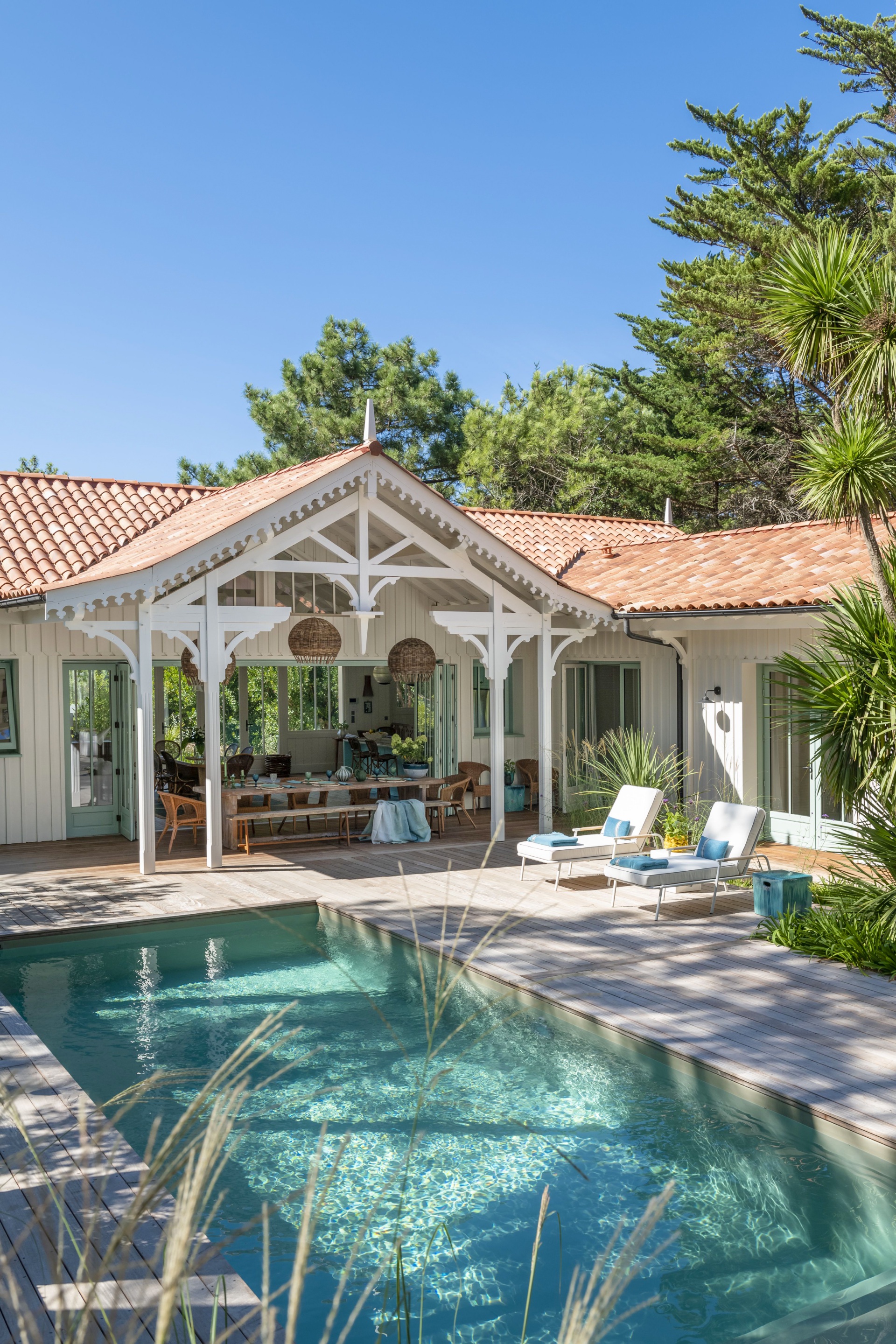 A swimming pool and outdoor alfresco area covered by a pitched roof.
