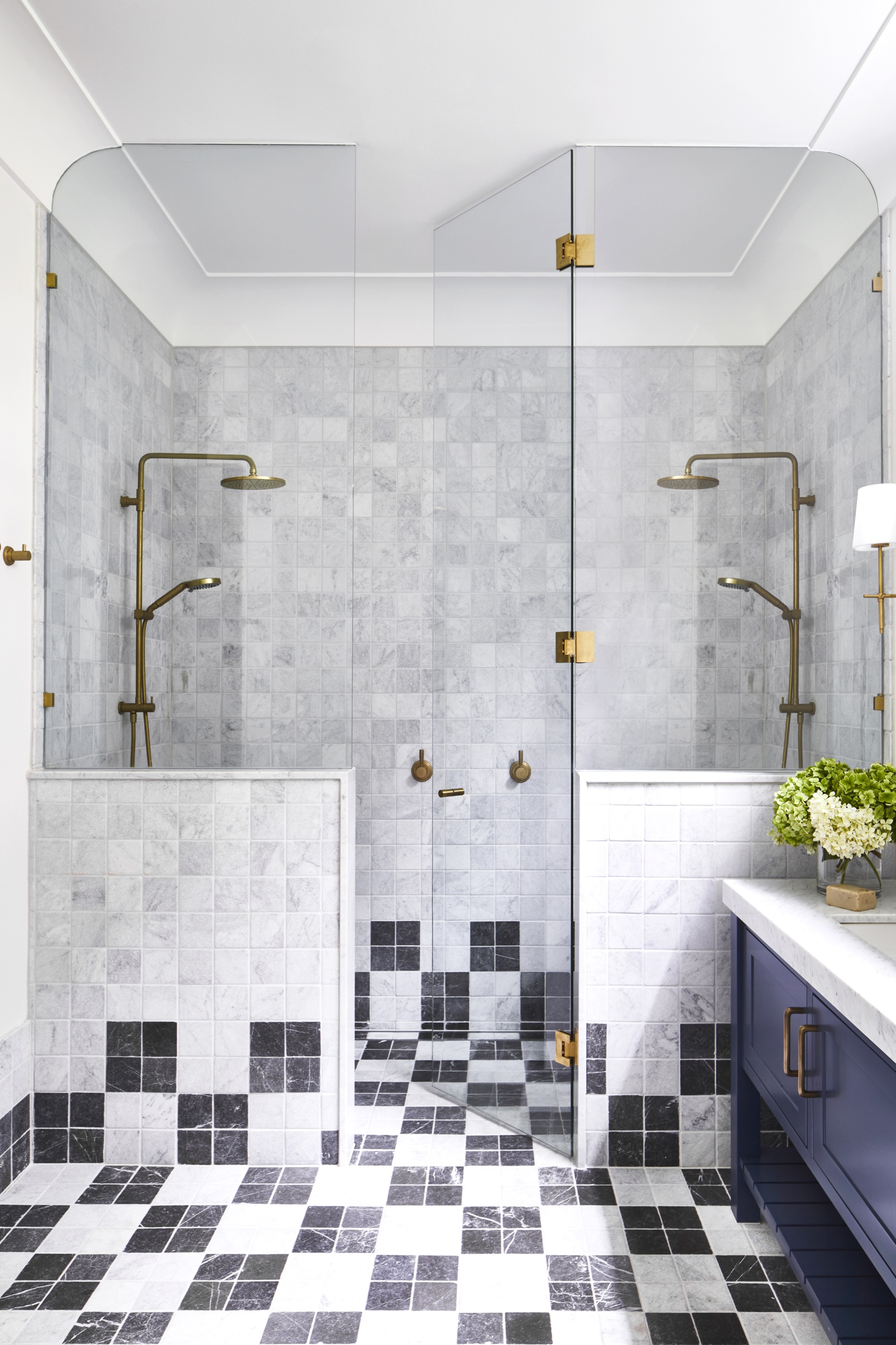 An ensuite with a double shower and marble black and white checked tiles.