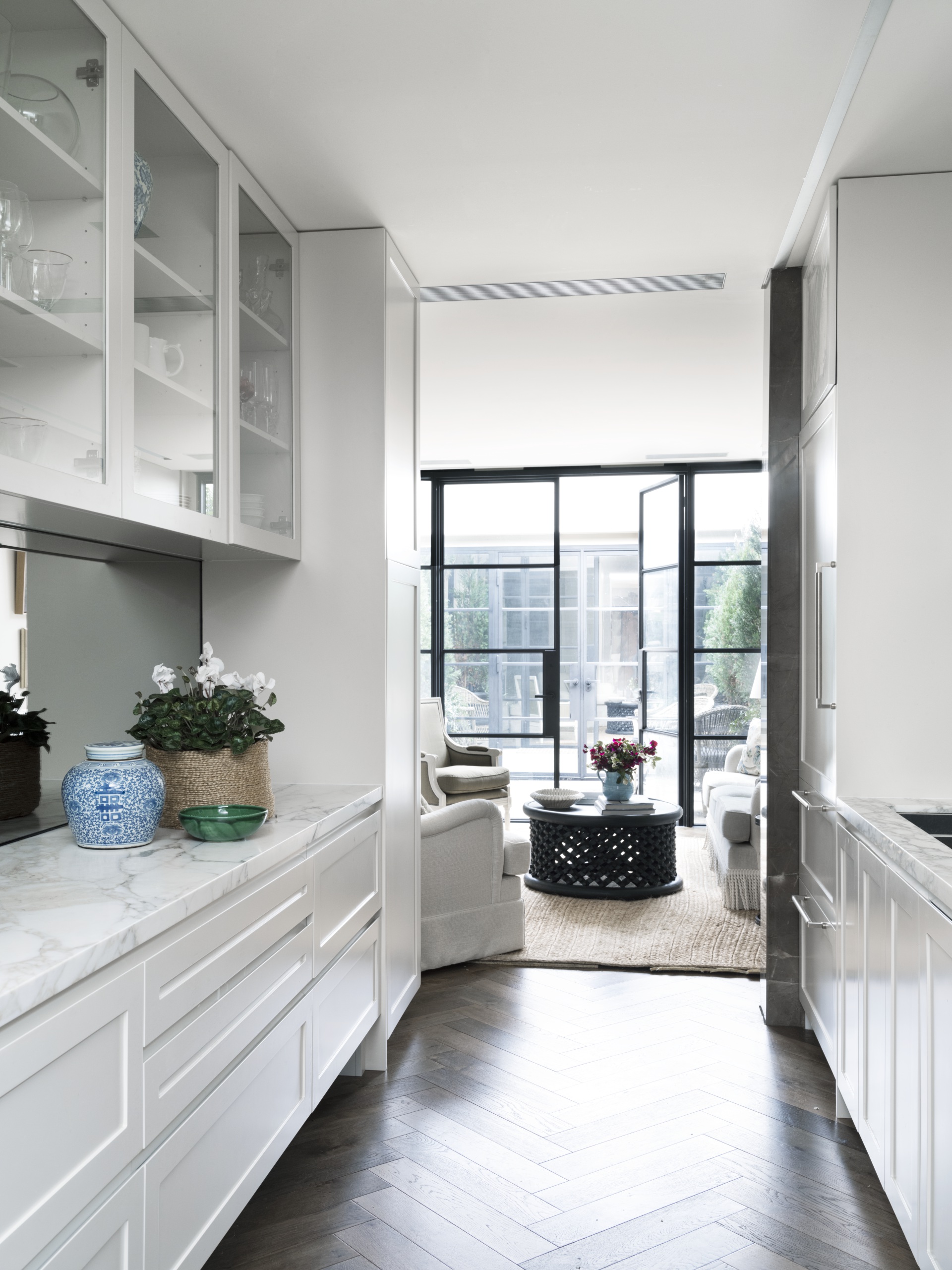 A long classic style kitchen with marble benchtops.