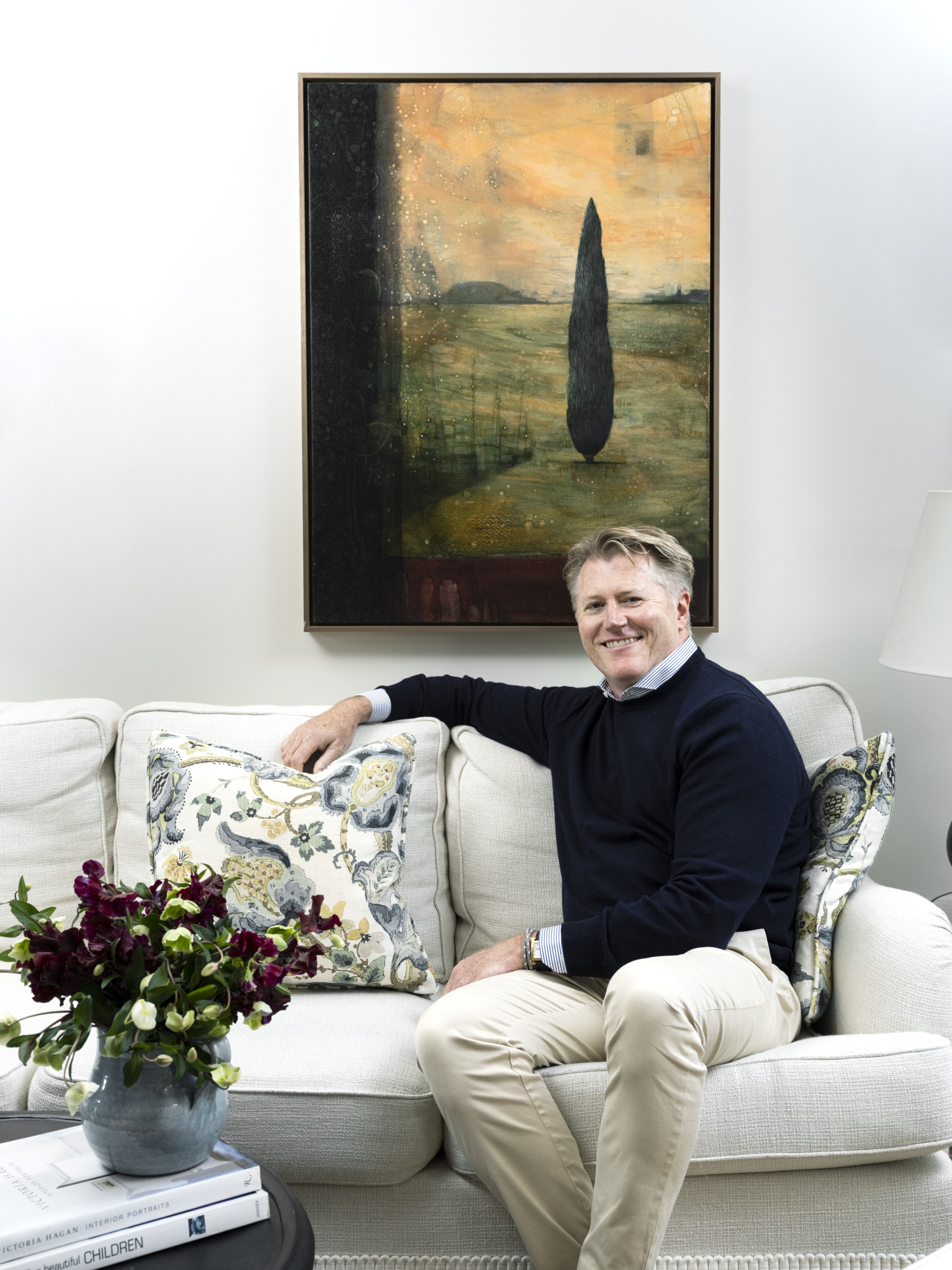 Interior designer Cameron Kimber sitting on a sofa.