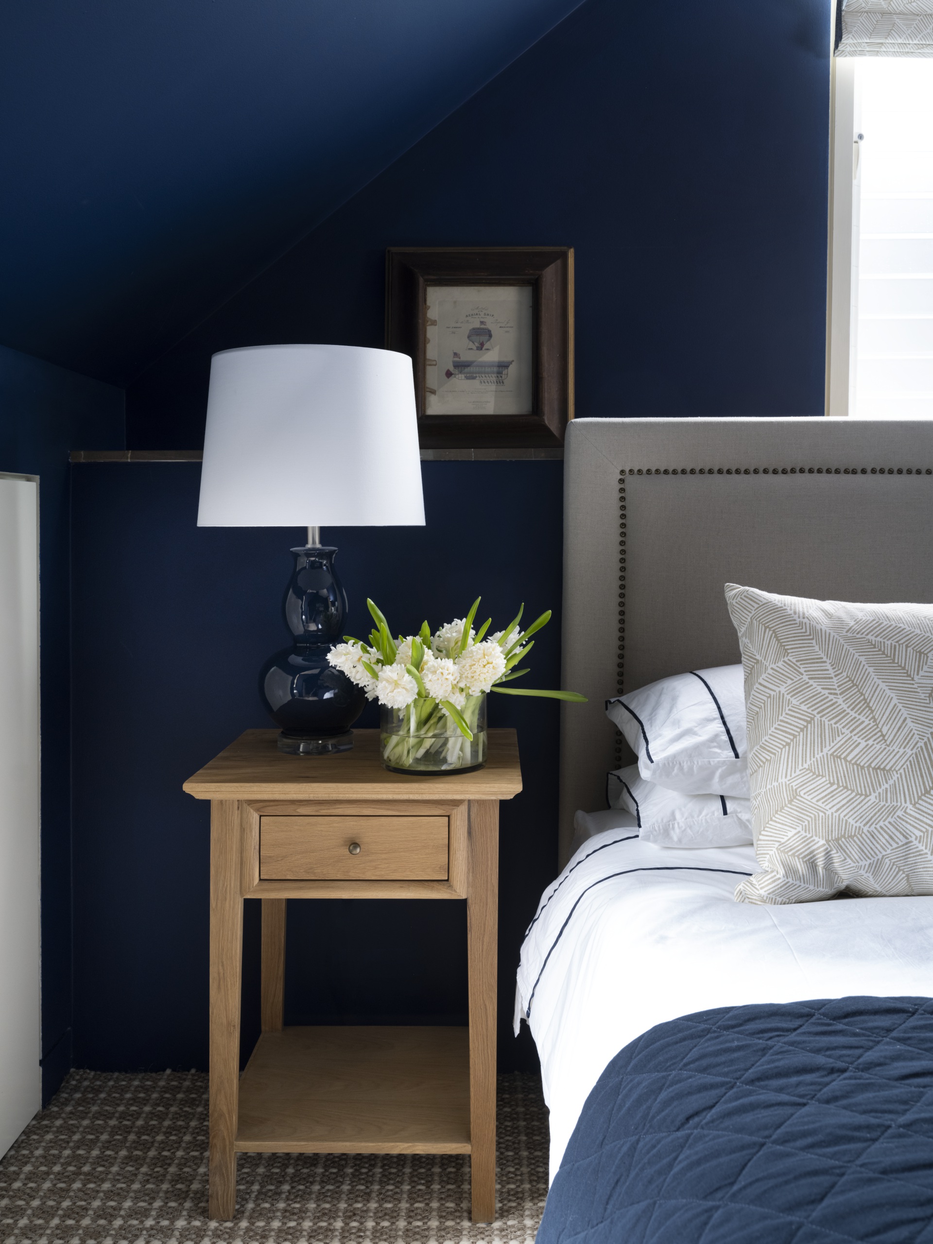 A navy guest bedroom with pops of white.