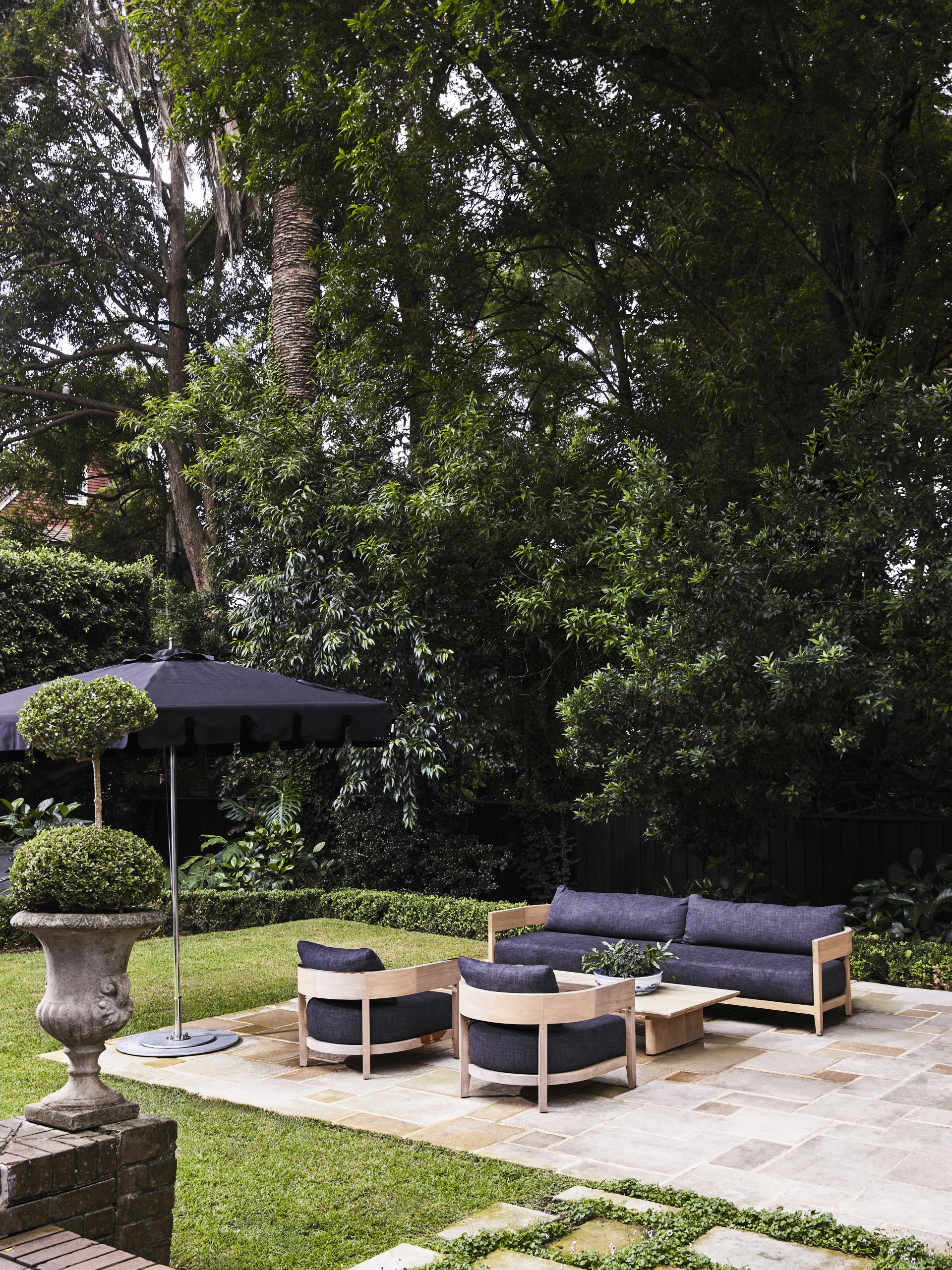 An outdoor seating area with blue chairs and a parasol.
