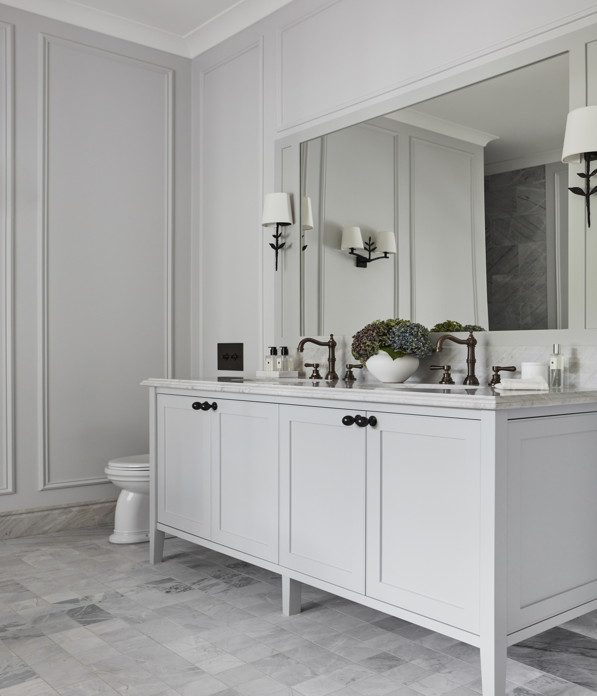 A country-style ensuite with a double vanity and wall wainscoting.