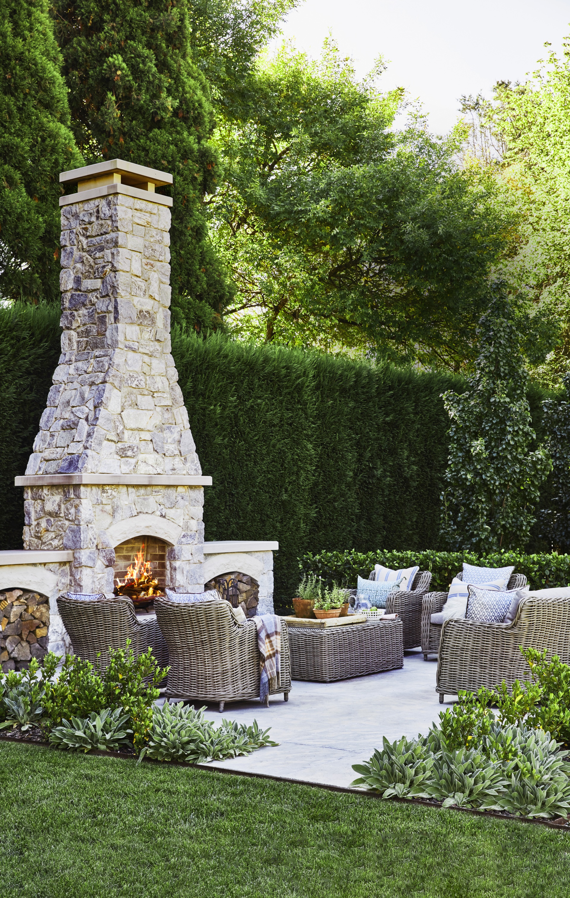 An outdoor seating area with a stacked-stone fireplace.