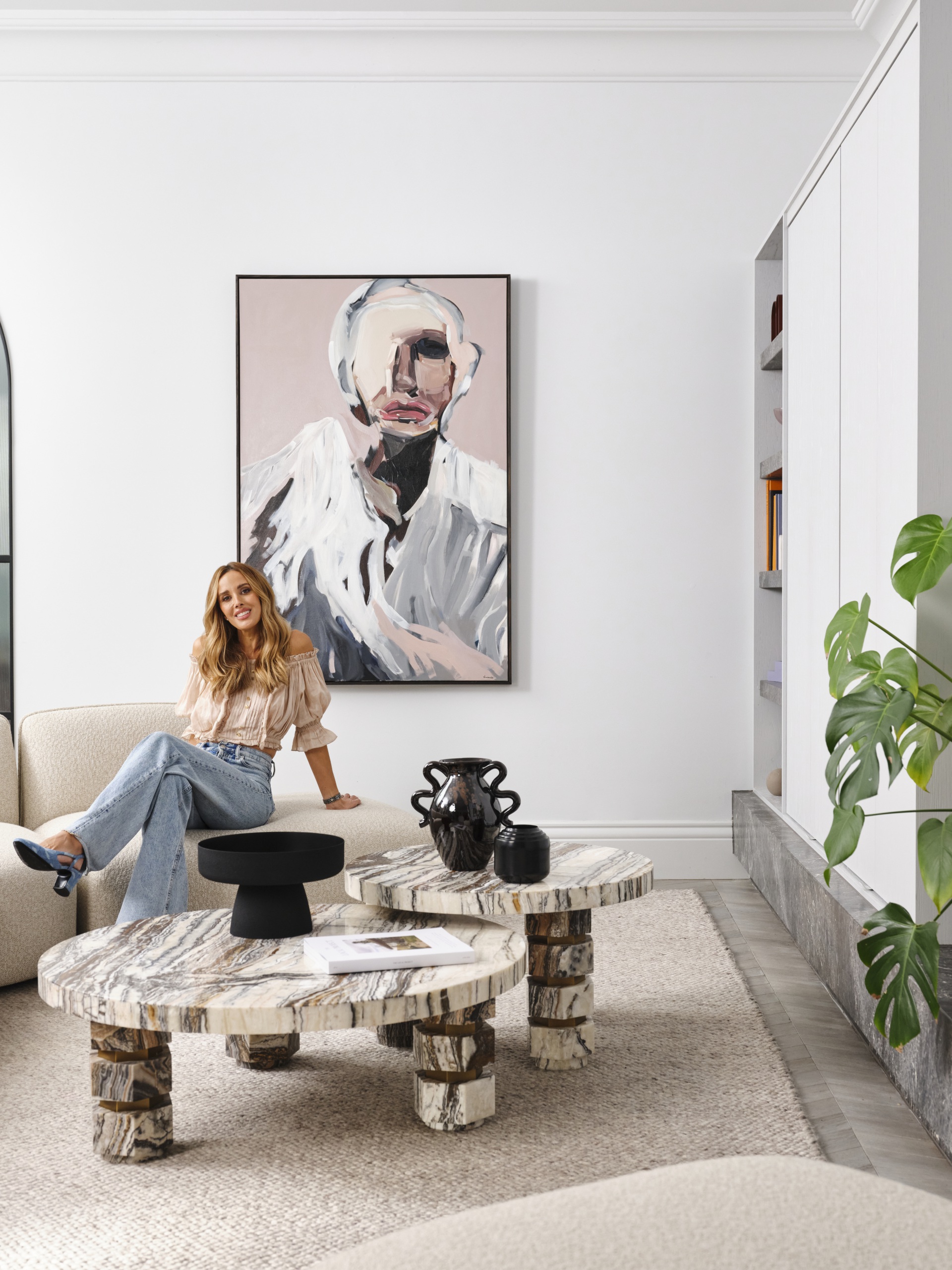 Bec Judd sits in her living room, beside the Tiramisu marble coffee table she created with Trit House.