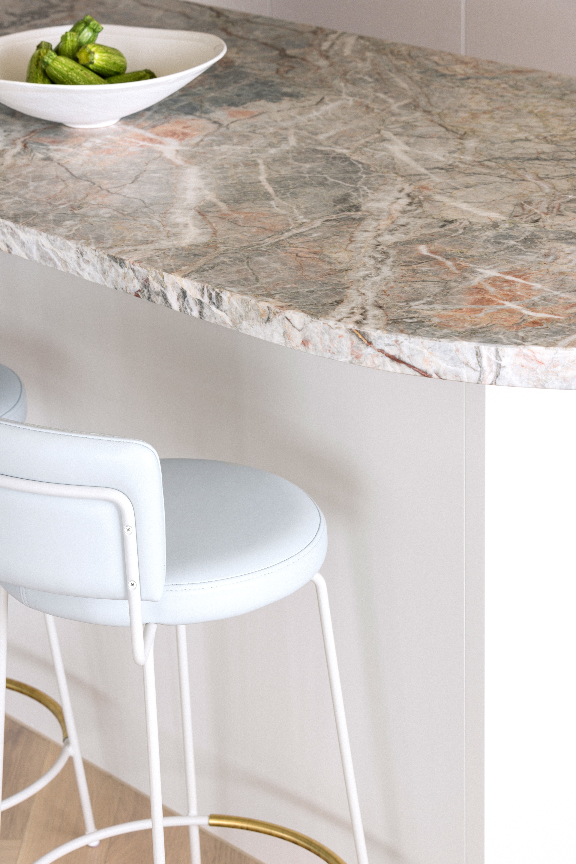 A white padded stool at a marble topped kitchen island.