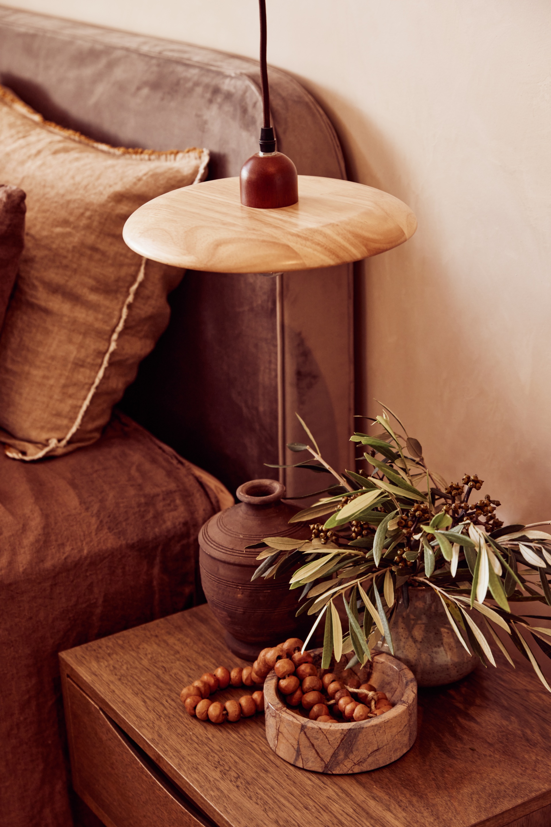 A timber bedside table with natural ceramics.