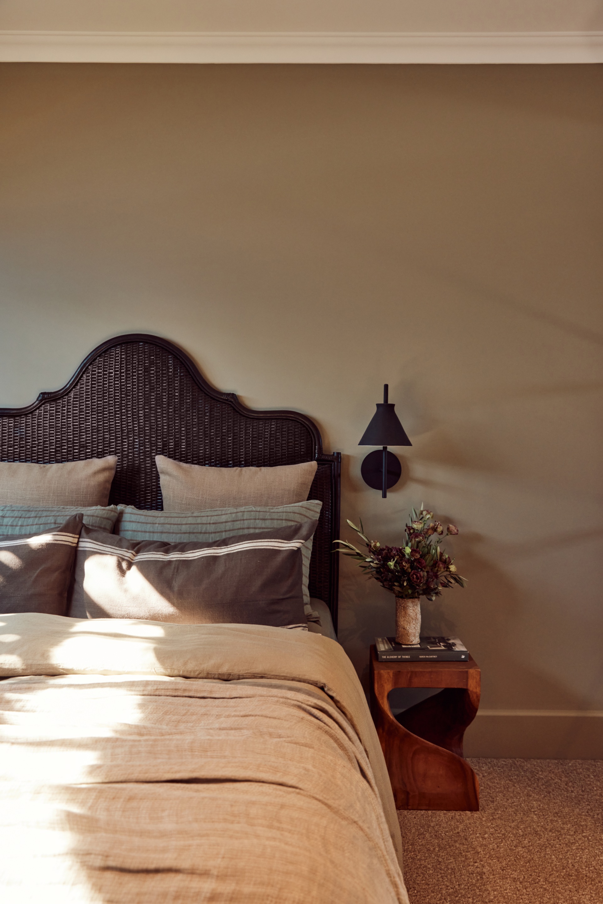 A Spanish resort style bedroom with a scalloped bedroom and natural furnishings.