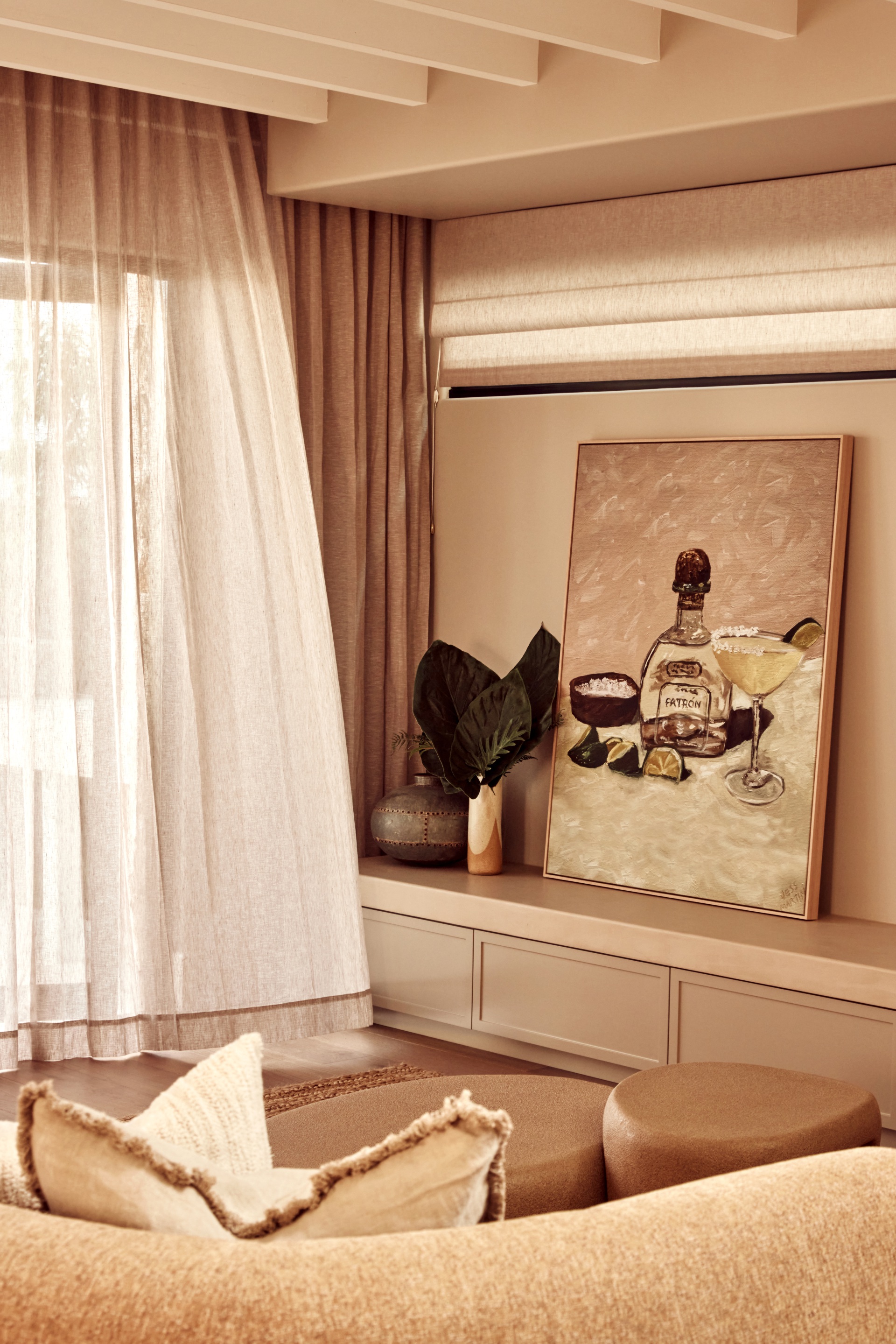 The Spanish resort style living area with a large tequila artwork and sheer curtains.