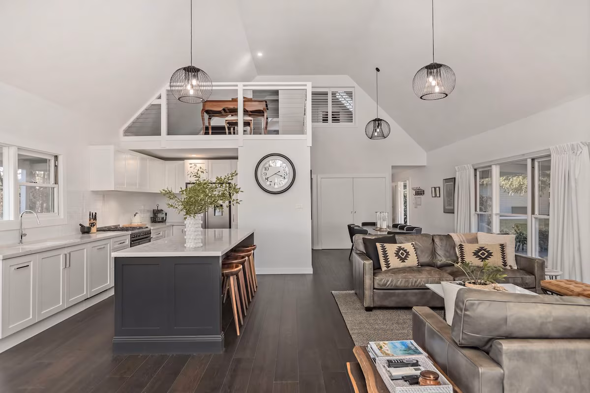 Kangaroo Valley accommodation interior white kitchen, living room with leather lounges and mezzanine