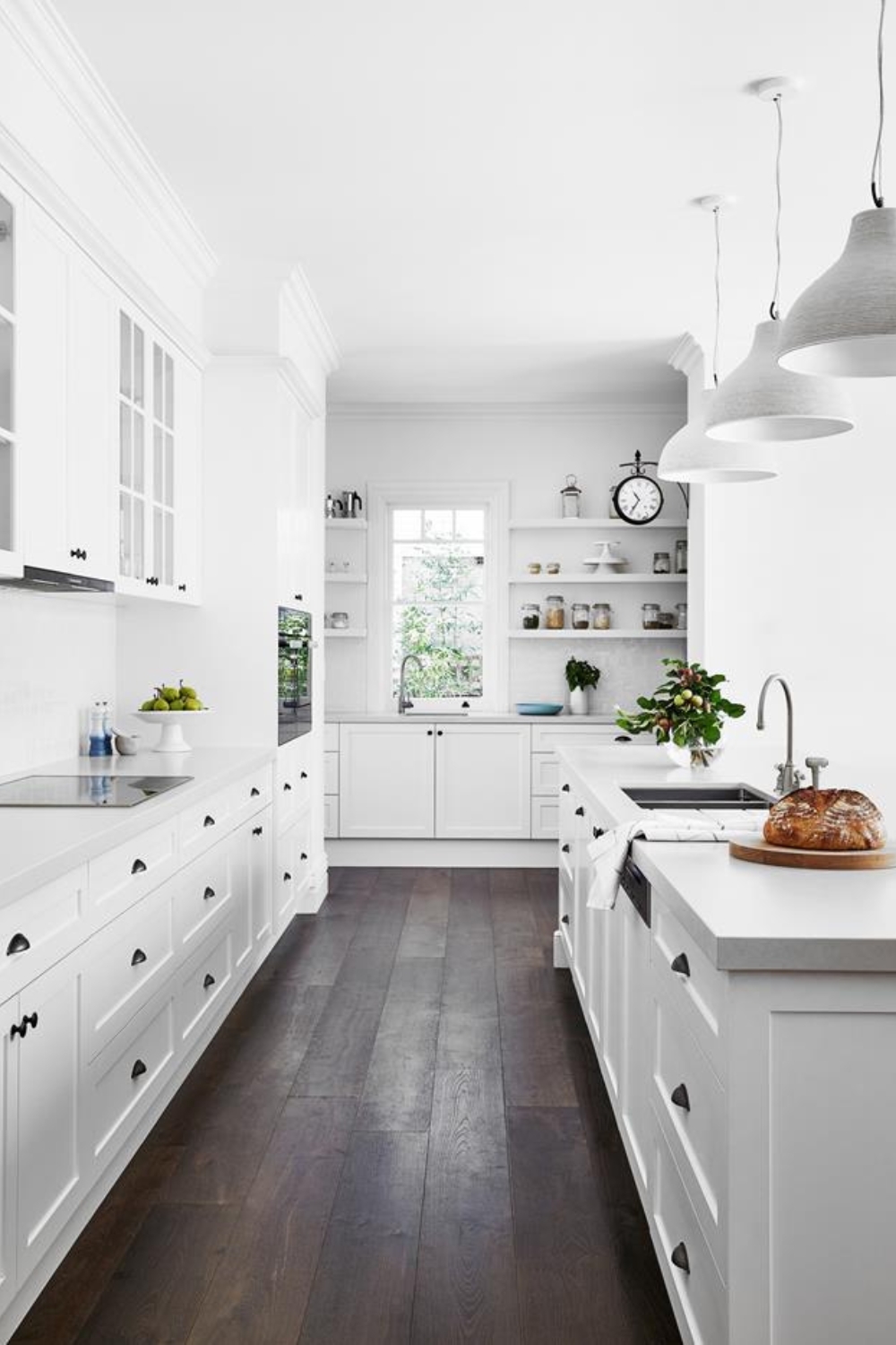 All white Hamptons style kitchen with large kitchen island bench and dark timber floors
