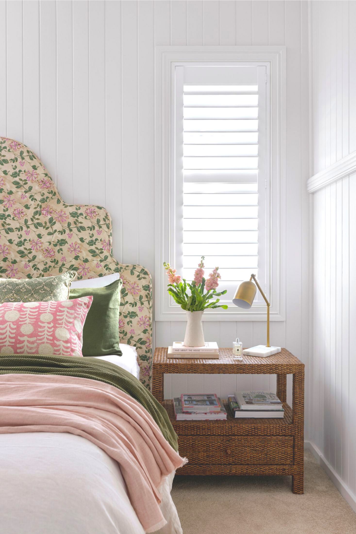 White bedroom with floral upholstered bedhead